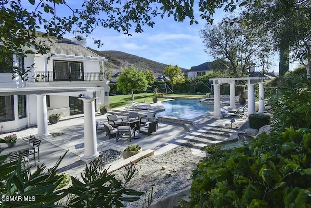 view of pool with a mountain view, a patio, and a jacuzzi