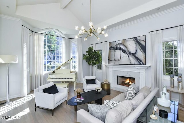 living room with light hardwood / wood-style floors, an inviting chandelier, vaulted ceiling with beams, and a fireplace