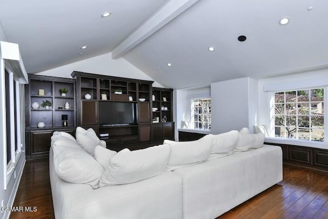 living room with a healthy amount of sunlight, dark hardwood / wood-style flooring, and vaulted ceiling with beams