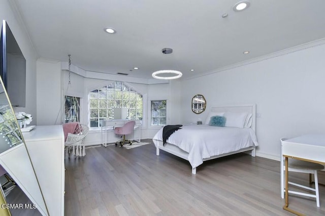 bedroom with washer / dryer, hardwood / wood-style floors, and ornamental molding