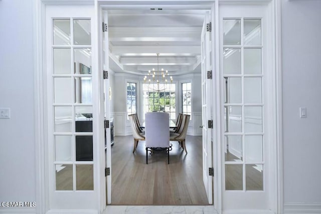 dining space featuring french doors, an inviting chandelier, hardwood / wood-style flooring, and beamed ceiling