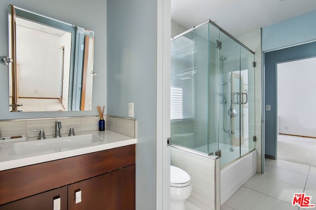 full bathroom featuring tile patterned flooring, vanity, enclosed tub / shower combo, and toilet