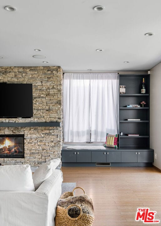 living room with a fireplace and light wood-type flooring