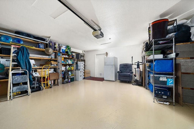 garage featuring white fridge and a garage door opener