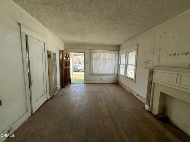 unfurnished living room featuring dark wood-type flooring and a textured ceiling