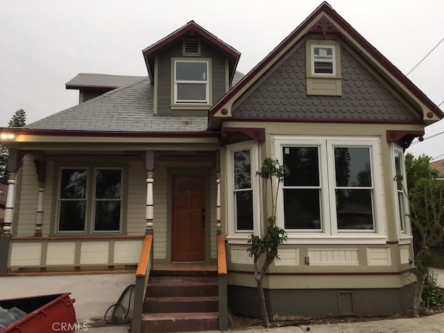 view of front of home with a porch and a shingled roof