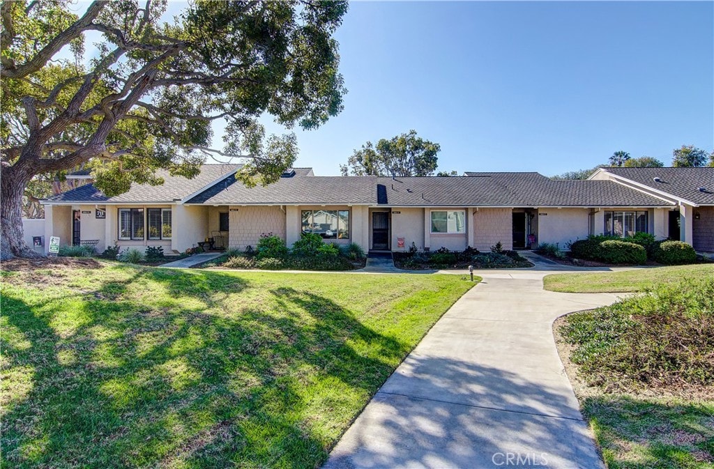 single story home featuring a front lawn