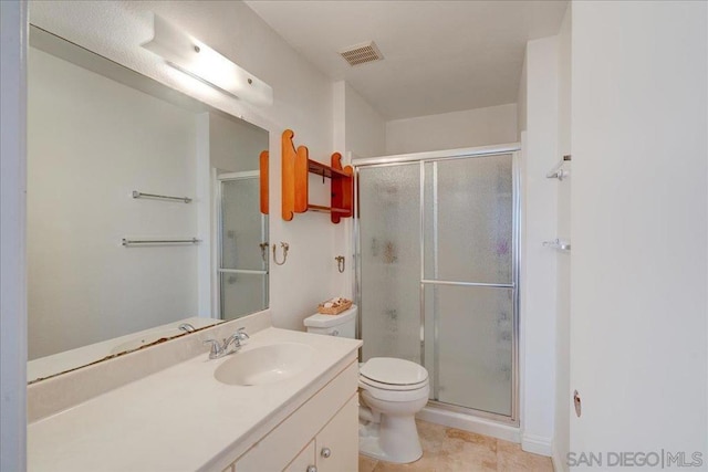 bathroom featuring an enclosed shower, vanity, and toilet