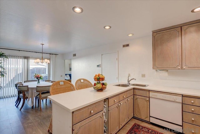 kitchen with white dishwasher, light brown cabinetry, sink, an inviting chandelier, and decorative light fixtures