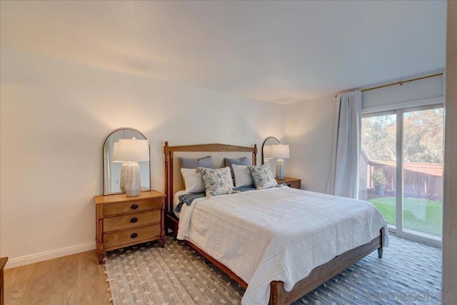 bedroom with wood-type flooring and access to outside