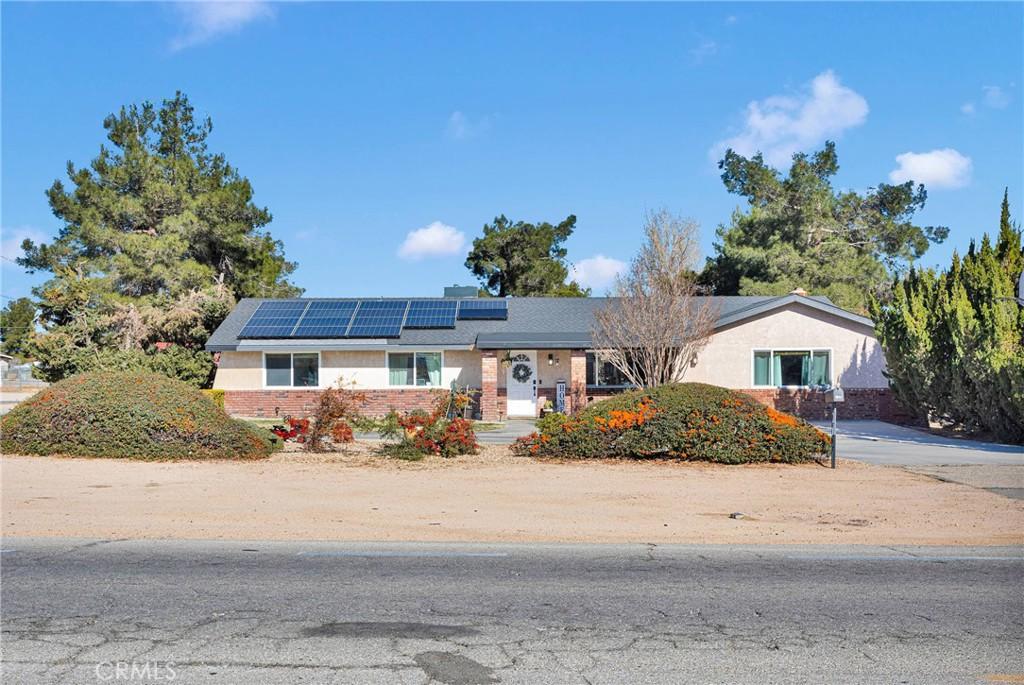 single story home featuring solar panels