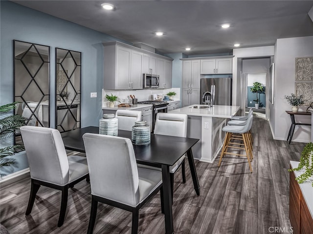 dining area featuring sink and dark hardwood / wood-style floors