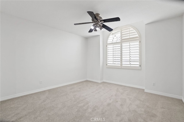 carpeted spare room with ceiling fan and baseboards