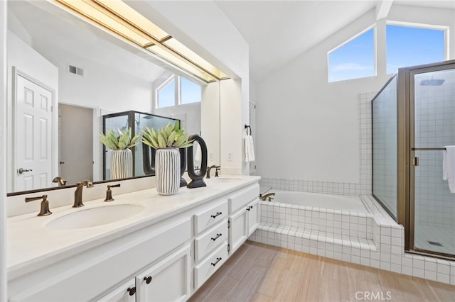 full bathroom featuring vaulted ceiling, a sink, visible vents, and a bath