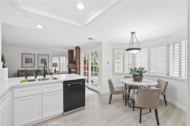 kitchen with visible vents, dishwasher, light wood-style flooring, crown molding, and a sink