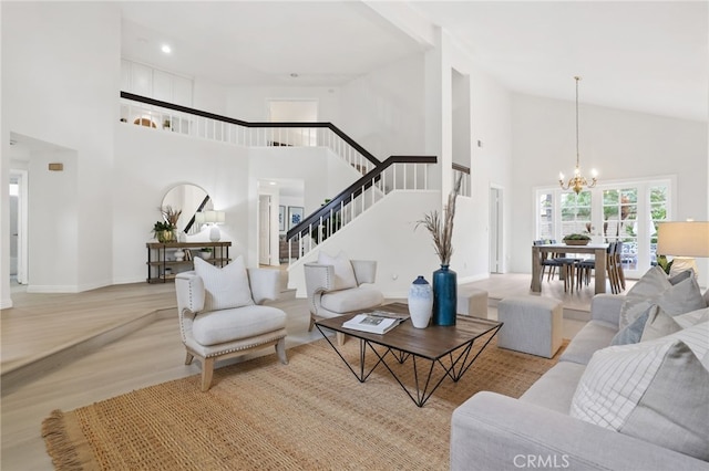 living room featuring high vaulted ceiling, stairway, wood finished floors, a chandelier, and baseboards