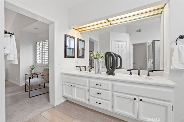 full bath with double vanity, a shower stall, visible vents, and a sink