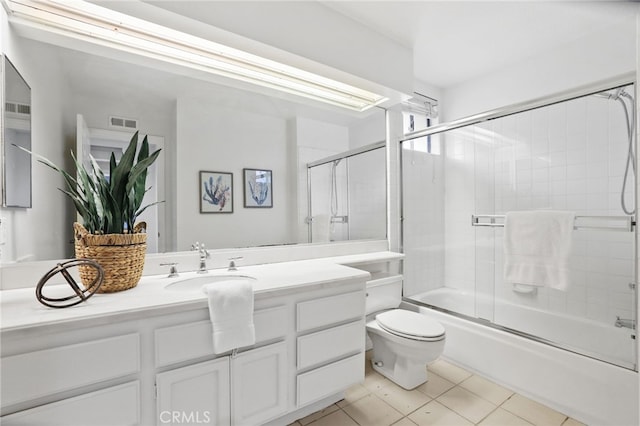 full bathroom featuring vanity, tile patterned floors, shower / bath combination with glass door, and toilet