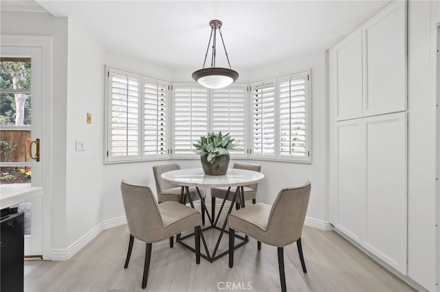 dining area with light wood finished floors, baseboards, and a wealth of natural light