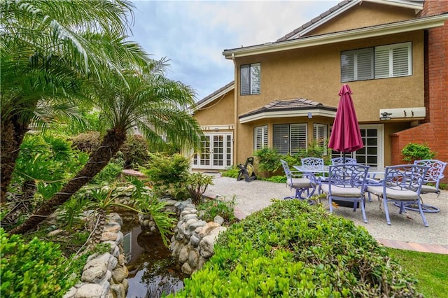 back of property featuring french doors, a patio, and stucco siding