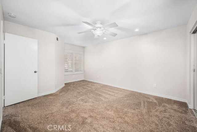 spare room featuring carpet flooring and ceiling fan