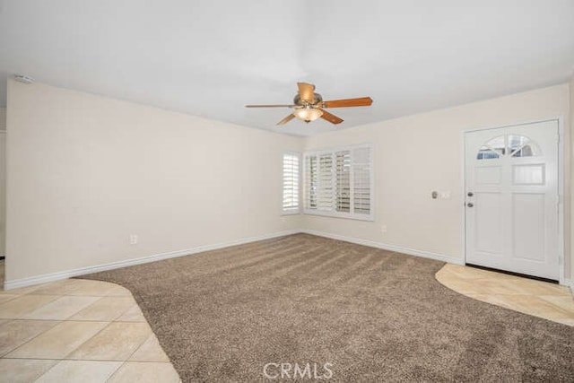 carpeted entryway with ceiling fan