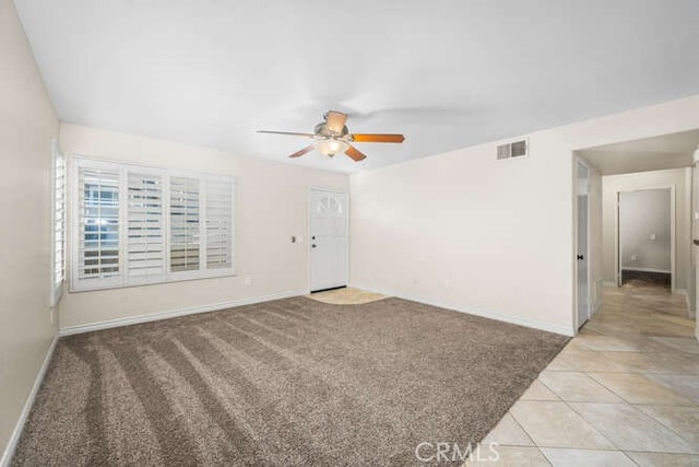 carpeted spare room featuring ceiling fan