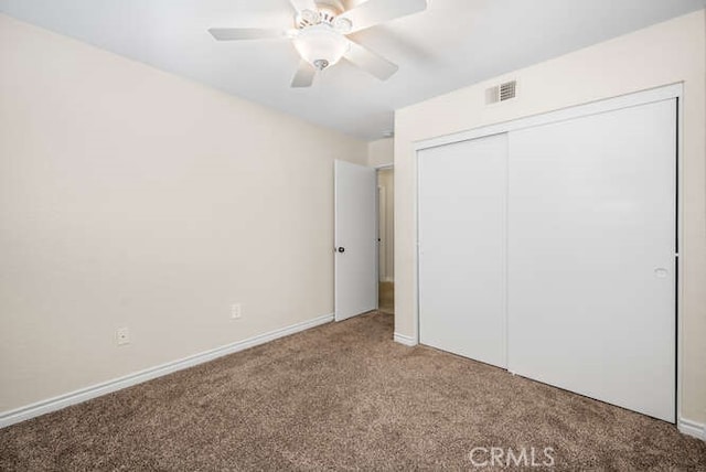 unfurnished bedroom with carpet flooring, ceiling fan, and a closet