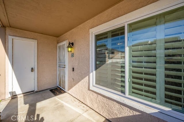 view of exterior entry with a patio