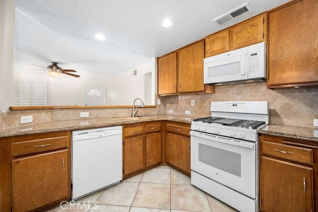 kitchen with kitchen peninsula, white appliances, ceiling fan, sink, and light tile patterned floors