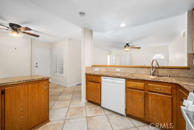 kitchen featuring dishwasher, stove, sink, decorative backsplash, and light tile patterned flooring