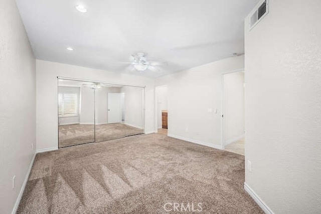 unfurnished bedroom with carpet floors, a closet, and ceiling fan