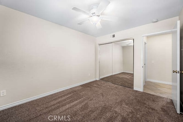 unfurnished bedroom featuring carpet, ceiling fan, and a closet