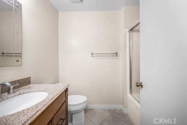 full bathroom with tile patterned floors, vanity, bath / shower combo with glass door, and toilet