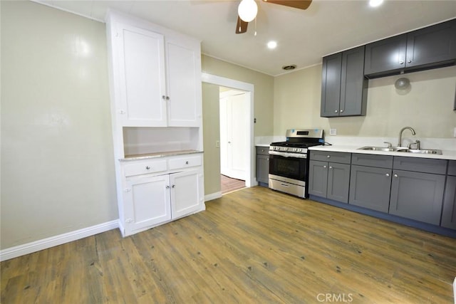 kitchen featuring gray cabinets, sink, wood-type flooring, and stainless steel range with gas stovetop