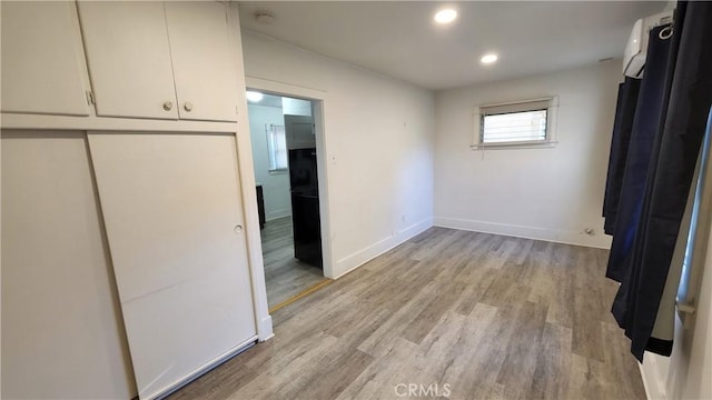 unfurnished bedroom with a closet and light hardwood / wood-style floors