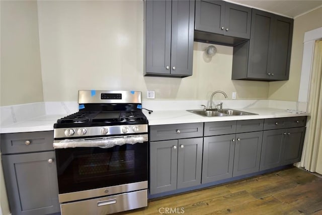 kitchen featuring gray cabinets, stainless steel range with gas cooktop, dark hardwood / wood-style floors, and sink