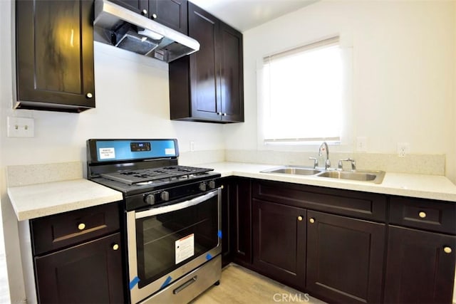 kitchen featuring sink, light hardwood / wood-style floors, dark brown cabinets, and stainless steel range with gas stovetop