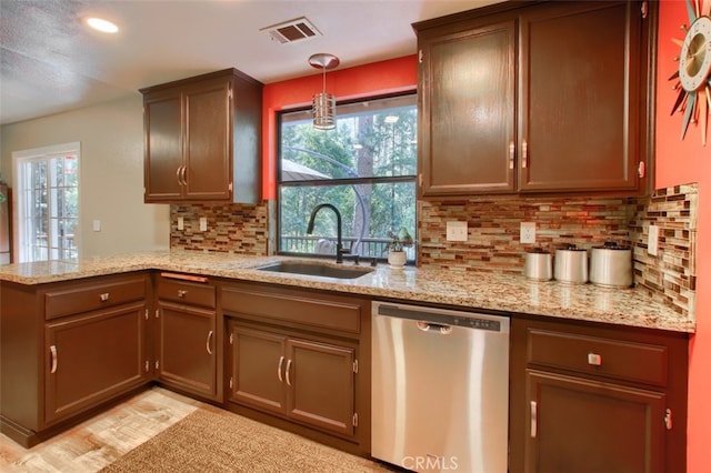 kitchen with dishwasher, sink, hanging light fixtures, tasteful backsplash, and kitchen peninsula