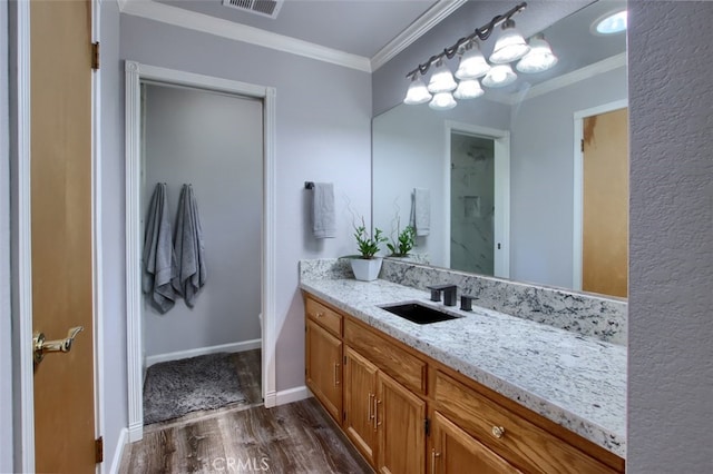 bathroom featuring vanity, hardwood / wood-style flooring, and ornamental molding