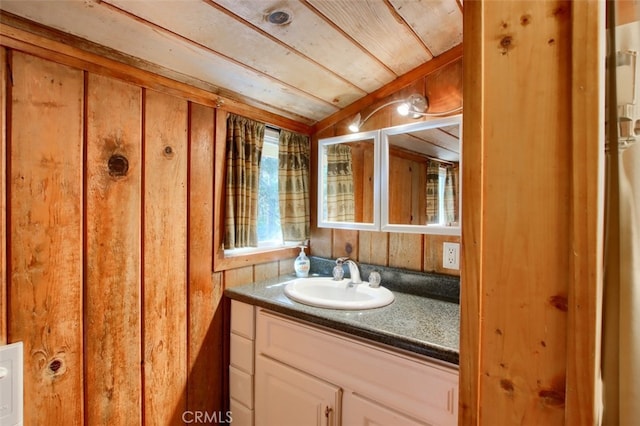 bathroom with vanity, wood walls, and wood ceiling