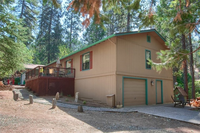 exterior space with a garage and a wooden deck