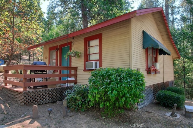 view of side of property with cooling unit and a wooden deck