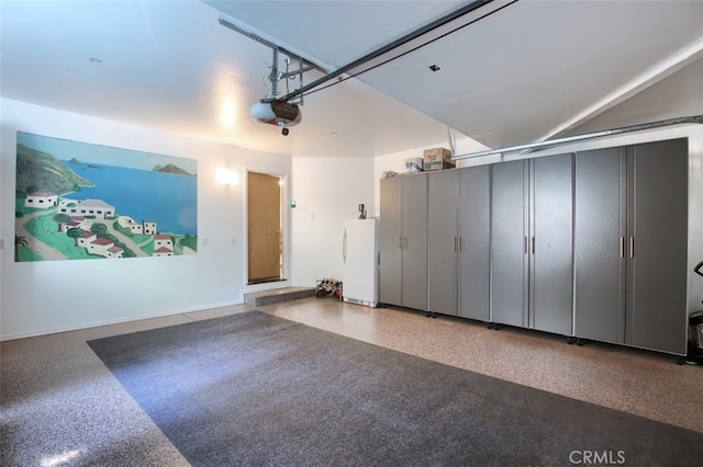 garage featuring white refrigerator and a garage door opener