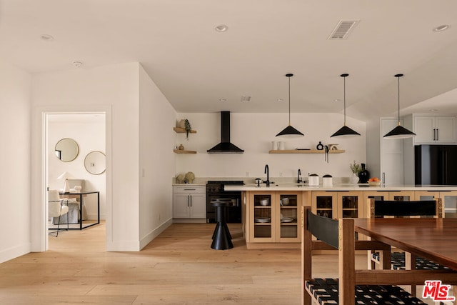 bar with white cabinets, wall chimney exhaust hood, range, and light hardwood / wood-style flooring