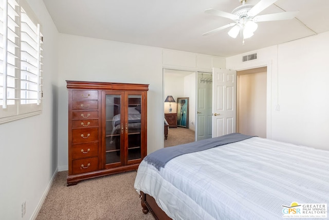 bedroom featuring ceiling fan, light colored carpet, and a closet