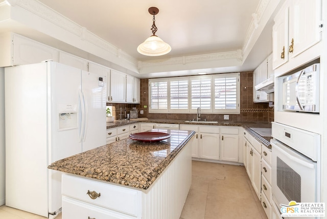 kitchen featuring a center island, white cabinets, white appliances, and sink