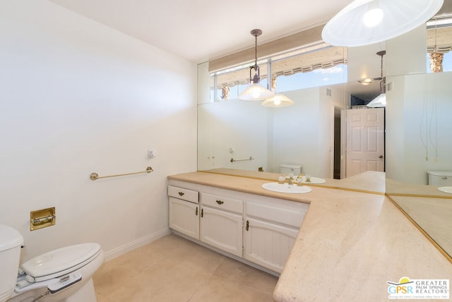 bathroom with a wealth of natural light, tile patterned flooring, vanity, and toilet