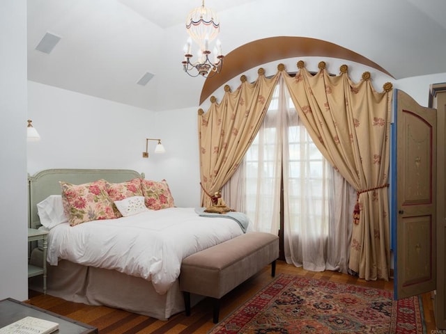 bedroom with lofted ceiling and a chandelier