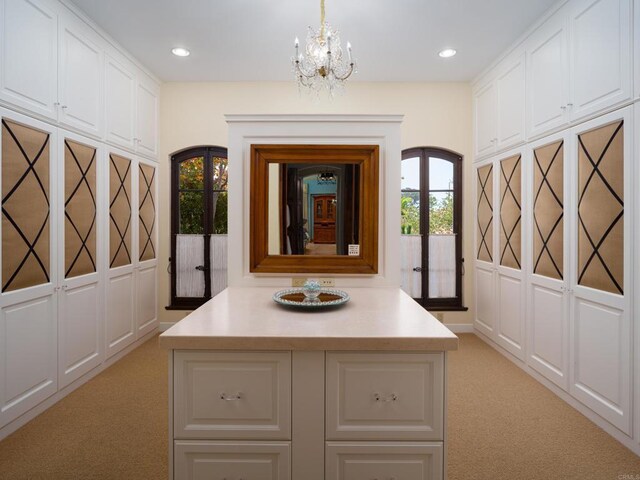 corridor with a chandelier, light colored carpet, and french doors